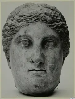 Marble head with wavy hair, shown front-on against a plain grey background