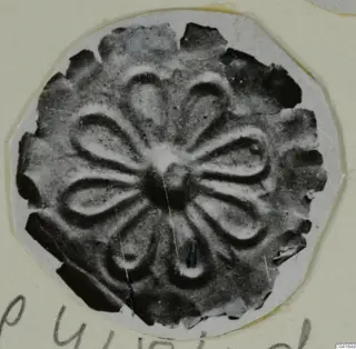 Disc-shaped gold ornament with petal-shaped lobes around a central boss, from Arsos