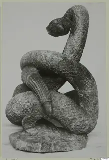 Stone sculpture of a coiled, scaled serpent-like figure with its head raised, from Soli
