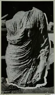 Carved stone sculpture fragment from Soli, showing a draped torso with deep folds