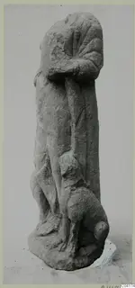 Stone sculpture of a standing figure in a long garment, with a small carved animal at its feet, from Soli
