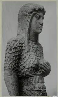 Statue from Soli in stone, head and upper body of a figure with a scale-patterned garment