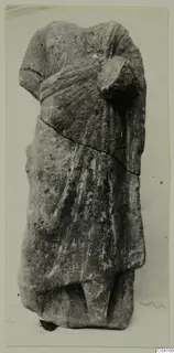 Headless stone statue of a standing draped figure from Soli, shown upright against a plain background
