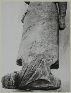 Stone statue fragment from Soli showing a draped lower body, fanned folds and a squared base