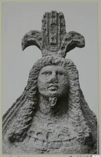 Stone statue of a head and upper body from Soli, with long wavy hair and a tall headdress with crescent-shaped side elements