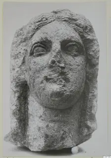 Stone statue head from Soli, face and hair in limestone with worn surface
