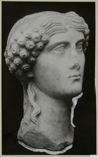 Carved marble head with rows of curled hair at the back and wavy locks across the brow