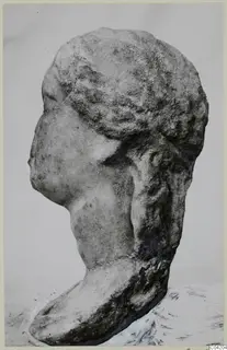 Profile of a carved marble head facing left, with wavy hair drawn back and a thick neck on a rounded base.