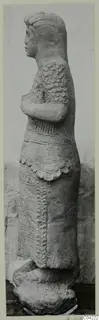Stone statue of a standing figure in side profile with folded arms, from Soli.