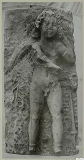 Carved stone relief of a standing nude male figure from Soli, on a weathered block