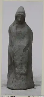 Terracotta figurine of a standing figure wearing a tall headdress, from Soli.