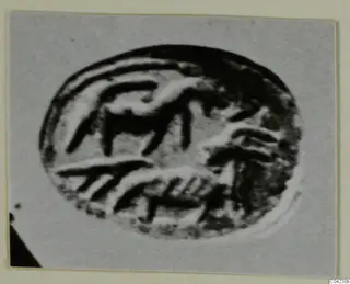 Close-up photograph of an oval engraved seal or gem with curved and straight incised strokes