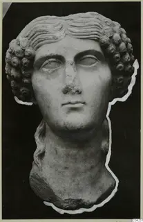 Marble sculpture of a head with curled hair and a long neck