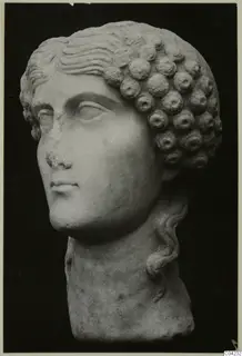 Marble head with wavy hair over the brow and rows of rounded curls at the side; the nose is chipped.