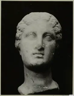 Marble head of a female figure against a dark background