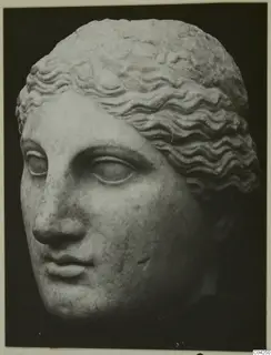 Marble head of a female figure with wavy hair, shown in three-quarter view against a dark background