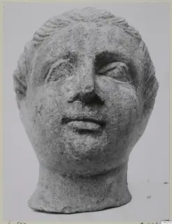 Stone head from a statuette found at Soli, with waved hair, deep-set eyes and a small mouth.