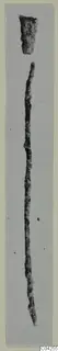 Bronze tools from Milia: a long, thin corroded rod and a short fragment, shown on a grey mount