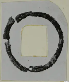 Corroded bronze ring made of several broken pieces, mounted on a grey card with a cut-out window, Milia