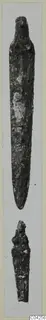 Two corroded bronze tools from Milia: a long tapering blade and a shorter broken fragment below it.