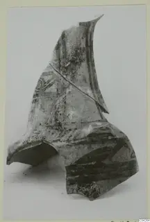 Large pottery sherd with dark painted bands and a curved motif, photographed on a pale background