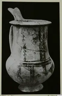 Pottery White Slip Ware jug from Milia, with a raised spout, a side handle and dark painted bands