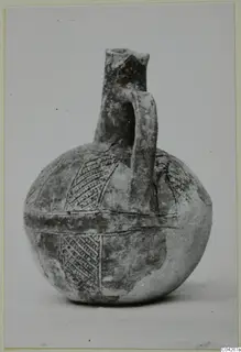 Round jug with a tall neck, strap handle and incised hatched bands on the body, Black Slip Ware, from Milia.