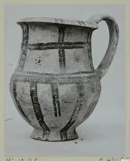 Pottery jug with a single loop handle, dark painted bands and dots on a pale slip, from Milia.