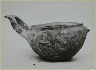 Pottery Monochrome Ware bowl from Milia with a raised handle, seen from the side