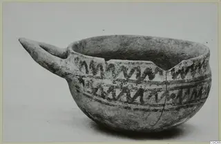 White Painted IV-V bowl from Milia with a long pointed handle and dark zigzag bands