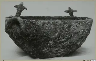 Corroded bowl from Amathus with a loop handle on one side and two small upright projections on the rim.