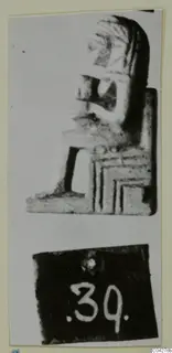 Seated figure sculpture in profile from Amathus, mounted on a card with a number label below