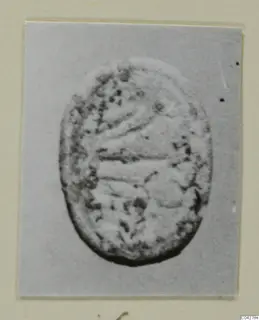 Oval seal-like object from Amathus, with curved incised lines and a dotted, worn surface