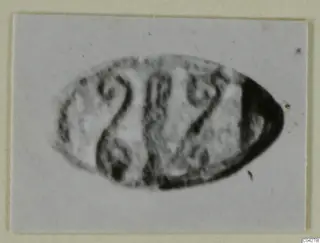 Oval glyptic object from Amathus with engraved markings, shown in a blurred close view.