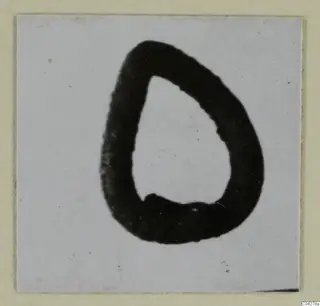 Small silver object, a thick dark loop with a teardrop outline, on a pale card mount