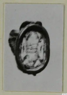 Oval glyptic seal or gem with a dark rim and a loop or mount on its left side