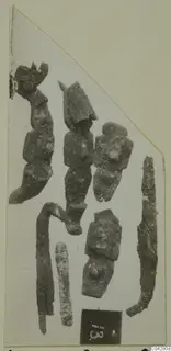 Corroded bronze objects from Amathus laid out on a card mount, with a dark number label at the lower right
