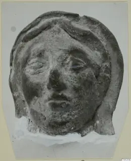 Terracotta head fragment from Marion, face framed by raised bands of hair