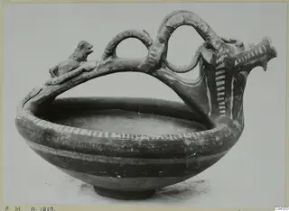 Pottery White Painted III-1 bowl with a high looping handle, a small animal figure on top and white painted bands