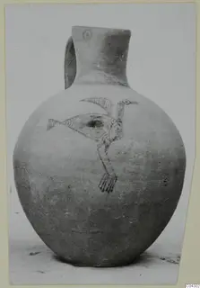 Round-bodied jug with a handle and a painted bird design on its body