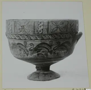 Painted pottery bowl on a ring foot with a single handle, decorated with bands of pattern and bird-like motifs