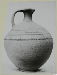 Pottery juglet with a single loop handle, a tall narrow neck and horizontal painted bands on the shoulder.