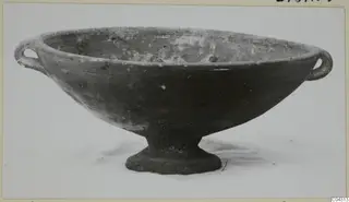 Pottery bowl with two loop handles and a short foot, photographed against a pale background