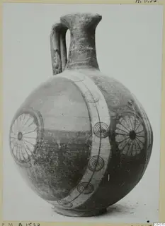 Round-bodied painted jug with a strap handle, a broad pale band and dark concentric circles and rosettes