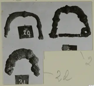 Three corroded bronze arch-shaped objects, each photographed separately and mounted with number labels and pencilled notes.
