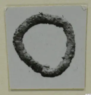 Ring-shaped bronze object from Amathus, photographed against a pale grey background.