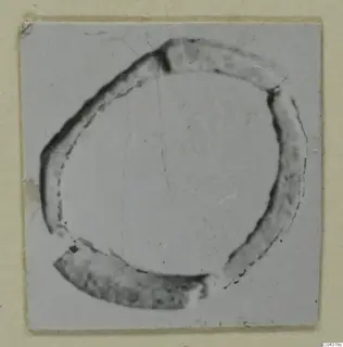 Broken ring-shaped faience object from Amathus, photographed close up on a card mount.