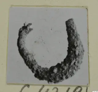 Corroded metal loop from Amathus, shown alone on a pale grey card mount