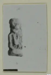 Small blurred figure of a standing human form, shown on a pale mount