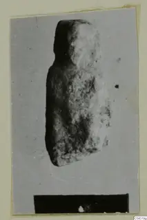 Fragment of a worn stone object from Amathus, photographed on a grey card mount